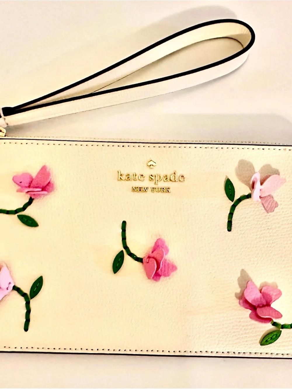 Kate Spade white wristlet with lilac floral appliqués and green leaves
